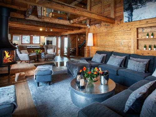 a living room with blue couches and a fireplace at Chalet Colombine - OVO Network in Les Villards-sur-Thônes