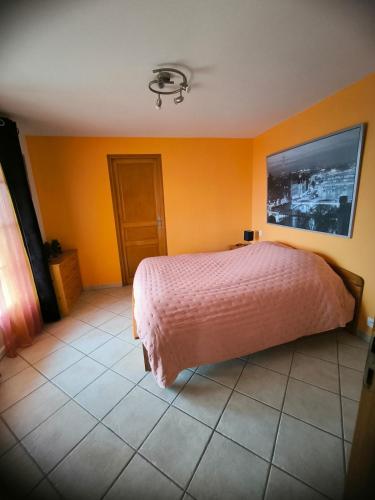 - une chambre avec un lit rose et des murs orange dans l'établissement L appartement d Adeline, à Saint-Vallier-de-Thiey