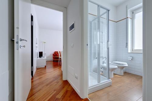 a bathroom with a toilet and a glass door at My House Apartments in Cremona
