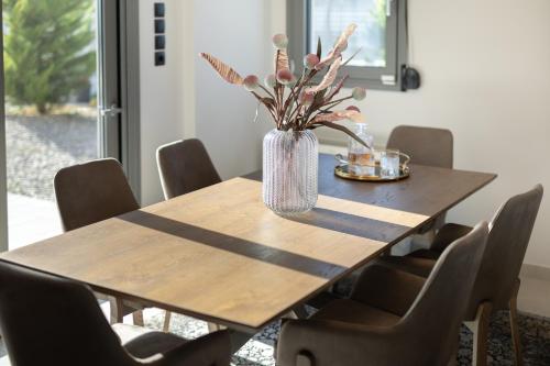 a dining room table with a vase of flowers on it at marYsol luxury maison in Eantio