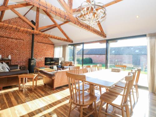 a living room with a table and chairs and a couch at Shorthorn Barn in Norwich