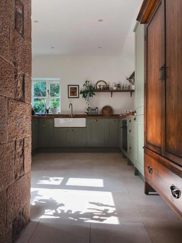 a large kitchen with a sink and a counter at Chapel Cottage- Coastal Somerset Retreat in Williton