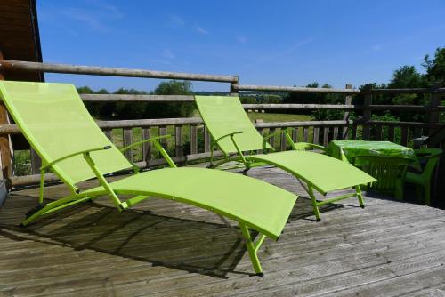 two green lawn chairs sitting on a deck at Gîte du Marais Deauville in Touques