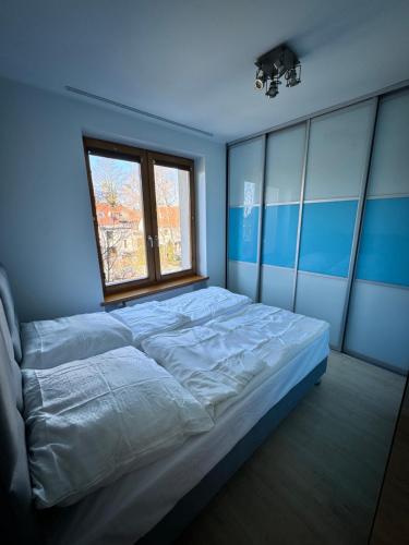 a large bed in a room with a window at Rybak30 in Gliwice
