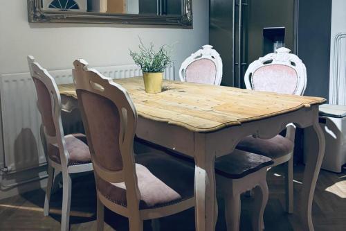 a wooden table with four chairs around it at Modern Lancashire stay with private Hot-tub in Skelmersdale