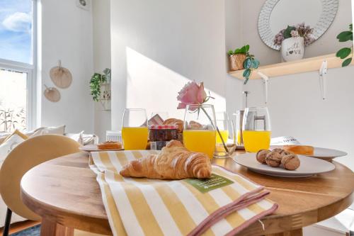 a table with croissants and glasses of orange juice at Apartment Big Ben, 10 mins to London Bridge, 5 min Croydon, 30 min Airport in London
