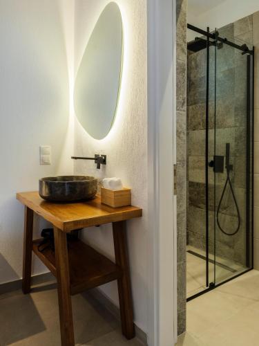 a bathroom with a sink and a mirror on a table at Secret Garden Apartments in Mýkonos City