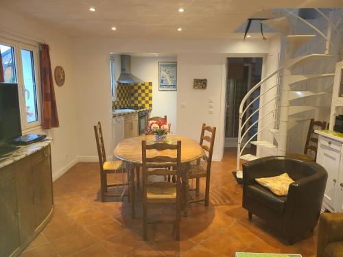 a kitchen and dining room with a table and chairs at Gîte du Marais Deauville in Touques