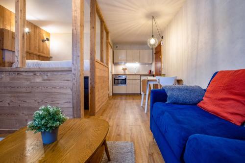un salon avec un canapé bleu et une table dans l'établissement Le Cry - Cosy studio 2pax - Free Parking - 5mn City Center, à Chamonix-Mont-Blanc