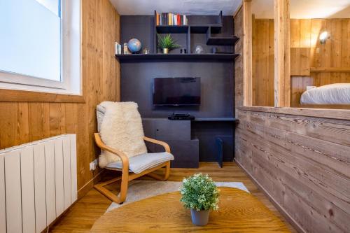 Cette chambre comprend une chaise, une télévision et un lit. dans l'établissement Le Cry - Cosy studio 2pax - Free Parking - 5mn City Center, à Chamonix-Mont-Blanc