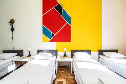 a room with four beds and a painting on the wall at ShortStayPoland Old Town C1 in Kraków