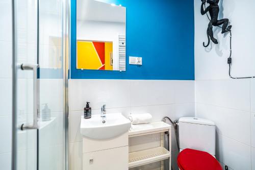 a bathroom with a sink and a red stool at ShortStayPoland Old Town C1 in Kraków