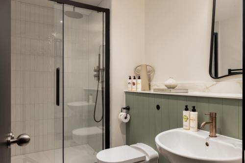 a bathroom with a shower and a sink and a toilet at Native Kings Wardrobe, St Pauls in London