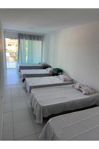 a row of beds lined up in a room at Wcasadepraia in Maragogi