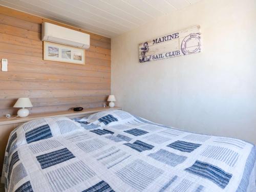 une chambre avec un lit et un panneau sur le mur dans l'établissement Appartement T2 en front de mer avec balcon à Narbonne Plage - FR-1-409-263, à Narbonne