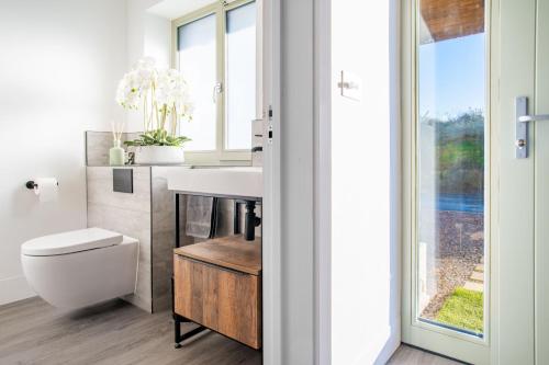 a bathroom with a sink and a toilet and a window at The Ark 4 in Southwold