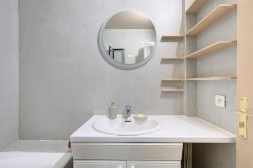 une salle de bain avec un lavabo blanc et un miroir dans l'établissement Trocadéro Love, à Paris