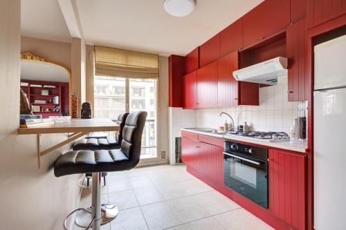 une cuisine avec des placards rouges et des chaises noires dans l'établissement Trocadéro Love, à Paris