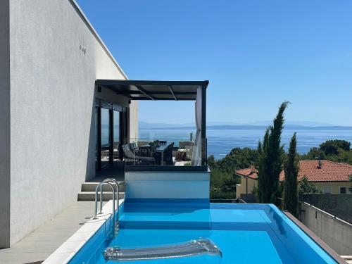 a swimming pool on the side of a house at Villa Loqua, Seaview & Private Pool in Lovran