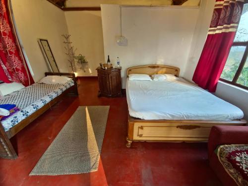 a bedroom with two twin beds and a couch at Coorg Tribal Land homestay in Kushālnagar