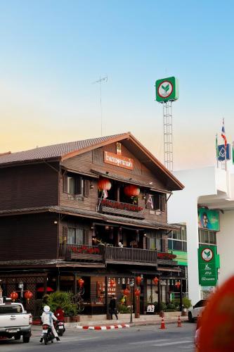 a building on a street with people on a motorcycle at Pukha Nanfa Hotel in Nan