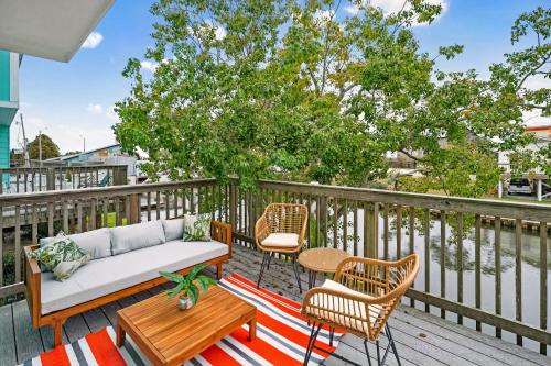 a patio with a couch and chairs on a deck at Waterfront Condo - Canal Views - Walk to Beach in Gulf Shores