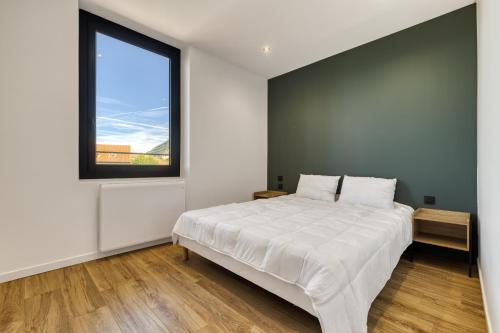 une chambre blanche avec un grand lit et une fenêtre dans l'établissement La Cosyne - chambre en colocation, à Collonges-sous-Salève