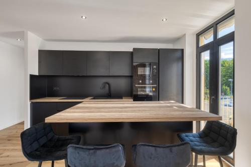 une cuisine avec une grande table et des chaises en bois dans l'établissement La Cosyne - chambre en colocation, à Collonges-sous-Salève