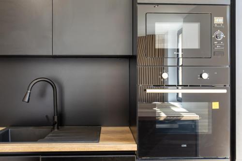 une cuisine avec un micro-ondes et un évier dans l'établissement La Cosyne - chambre en colocation, à Collonges-sous-Salève