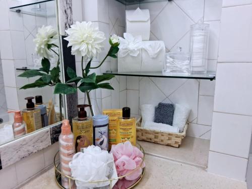 a bathroom counter with a mirror and a vase with flowers at Marreiro's house Algarve - Child friendy - Private Pool in Lagos