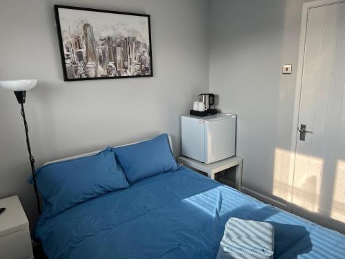 a bedroom with a blue bed and a picture on the wall at Greensleeves in Bristol