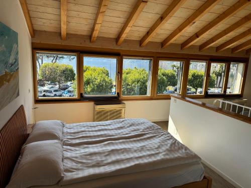 a bedroom with a bed in a room with windows at Osteria Ascona in Ascona