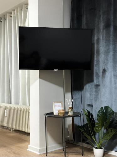 a flat screen tv on a wall in a living room at LUYS Apartment in Brussels