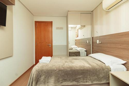 a bedroom with two beds and a mirror at Apartamento Lindo e Moderno no Centro de Gramado in Gramado