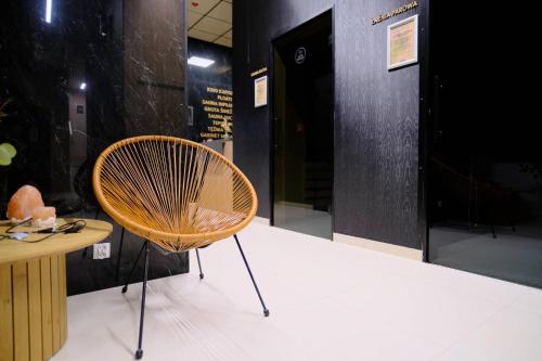 a chair sitting next to a table in a room at WR SPORT HOTEL & SPA - Centrum Sportu i Rozrywki in Rzeszów