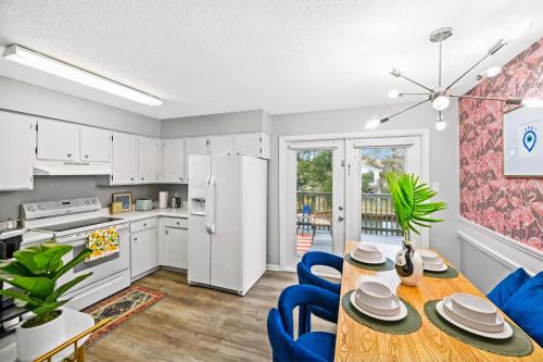 a kitchen and dining room with a table and blue chairs at Waterfront Condo - Canal Views - Walk to Beach in Gulf Shores