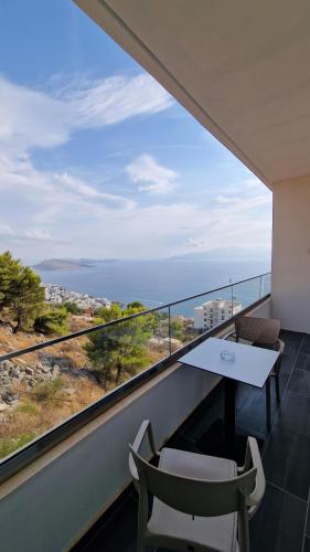 a balcony with a table and chairs and a view of the ocean at Sunset Shoreline Saranda - Sea View - Free Private Parking - Pool in Sarandë