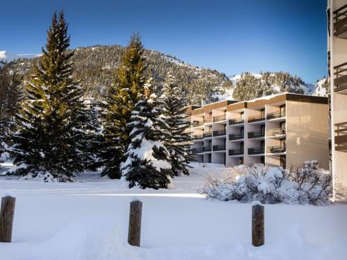 un panneau devant un bâtiment dans la neige dans l'établissement Studio cosy RDC à Montgenèvre avec parking - FR-1-266-78, à Montgenèvre