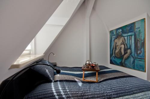 ソポトにあるImperial Apartments - Galeriaのベッドルーム1室(ベッド1台付)が備わります。壁には絵画が飾られています。