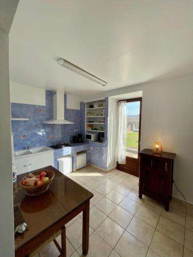 - une cuisine avec un bol de fruits sur une table dans l'établissement La Maison du Carrier, à Ruoms