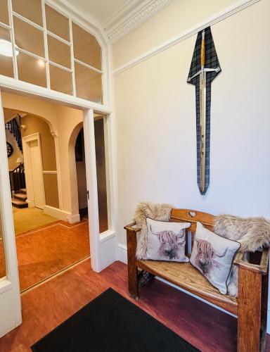 a living room with a couch and a cross on the wall at The Claymore Guest House in Pitlochry