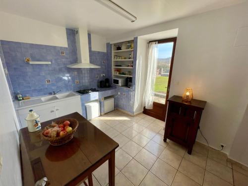 - une cuisine avec un bol de fruits sur une table dans l'établissement La Maison du Carrier, à Ruoms