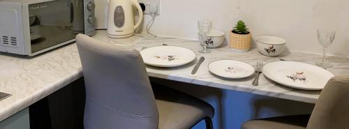 a kitchen counter with plates and utensils on a table at Farmhouse studio near Shrewsbury in Shrewsbury
