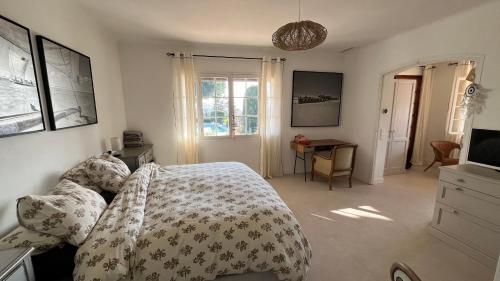 une chambre avec un lit, un bureau et une télévision dans l'établissement Nouveau Le Mas des Serens, à La Gaude