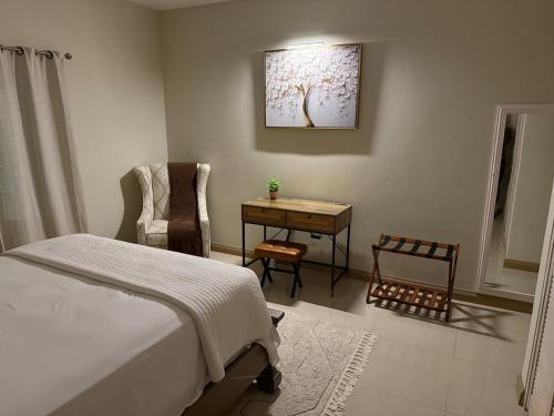 a bedroom with a bed and a table and a desk at Experience Luxury & Serenity-Your Perfect Getaway in Ocho Rios