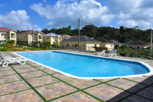 a swimming pool in a yard with houses at Experience Luxury & Serenity-Your Perfect Getaway in Ocho Rios