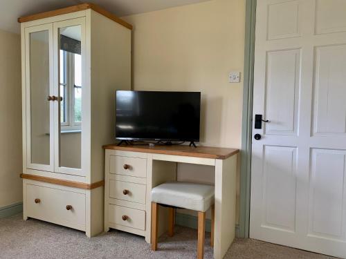 a bedroom with a desk with a tv and a mirror at Farmhouse studio near Shrewsbury in Shrewsbury