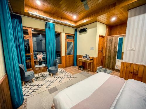 a bedroom with a bed and a desk at The Elevia, Jibhi in Jibhi