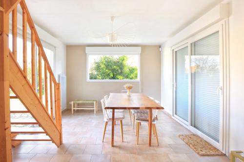 une salle à manger avec une table et des chaises en bois dans l'établissement Maison 