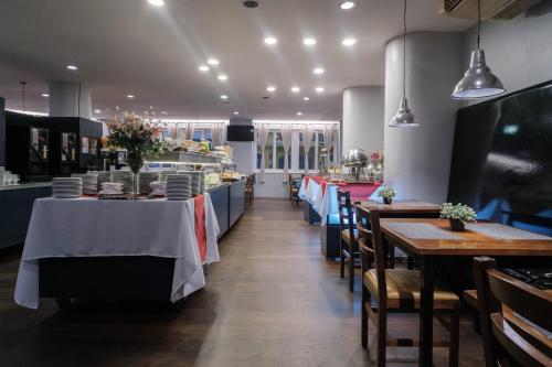 a restaurant with tables and chairs in a room at Hotel Normandie in Sao Paulo